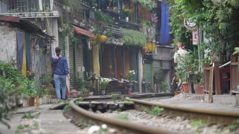 Vida-Cotidiana-En-La-Calle-Del-Tren-Con-Lugareños-En-El-Famoso-Casco-Antiguo-De-Hanoi,-Vietnam