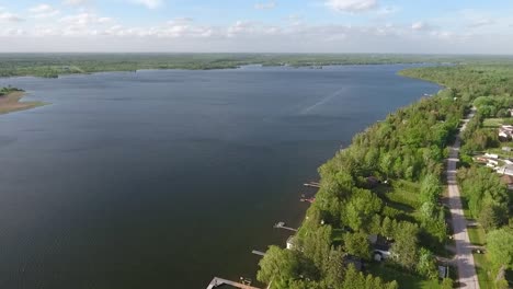 Drone-flying-along-lakeside-town-in-summer-in-Kawartha-Lakes