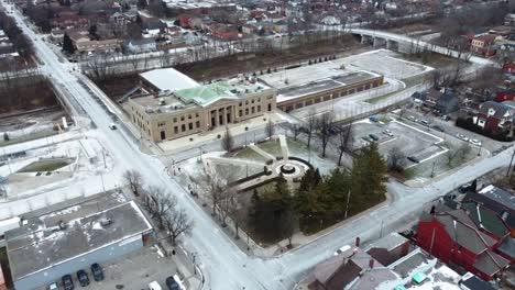 Aerial-shot-flying-over-a-snowy-park-near-a-train-station-in-Hamilton