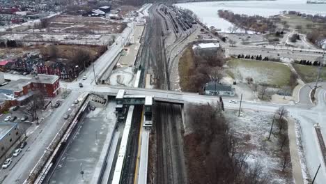 Drone-flying-away-from-snowy-train-station-in-Hamilton