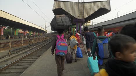 Gente-Caminando-Hacia-La-Salida-Con-Su-Equipaje-Después-De-Embarcar-En-La-Estación-De-Tren,-Kolkata,-Bengala-Occidental