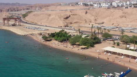 Touristen-Entspannen-Sich,-Schwimmen-In-Der-Nähe-Von-Korallen-Und-Bräunen-Sich-Am-Moshe-Beach-In-Eilat