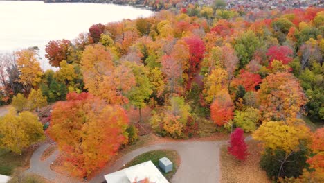 Bird's-eye-view-of-a-park-filled-with-vibrant-colors-of-the-fall-leaves-scattered-throughout-the-park,-and-the-children-running-and-jumping-on-the-colorful-climbing-frames