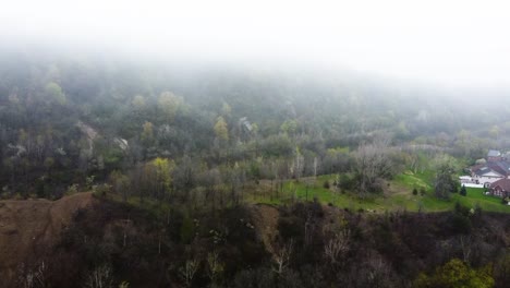 Drone-flying-towards-a-foggy-mountain-during-spring-time-in-Hamilton