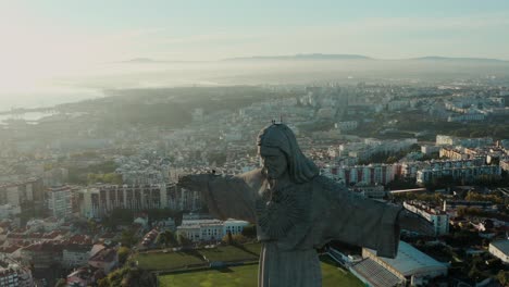 Großes-Christusdenkmal-In-Der-Stadt-Lissabon-Bei-Sonnenuntergang,-Drohnenaufnahmen-Der-Jesusstatue