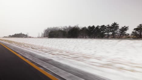 Road-filled-with-snow,-moving-shot,-winter-highway,-freeway-Canada,-USA,-truck-and-car-in-background