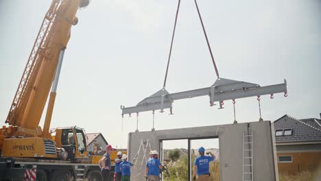 Trabajadores-De-La-Construcción-Instalando-Travesaños-Metálicos-En-La-Pared-Desde-La-Grúa