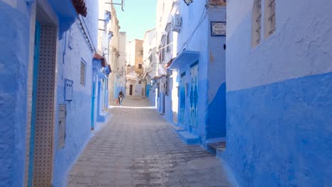 Pov-of-walking-along-the-peaceful-and-vibrant-Chefchaouen-narrow-street,-Blue-Colored-walls,-Slow-motion