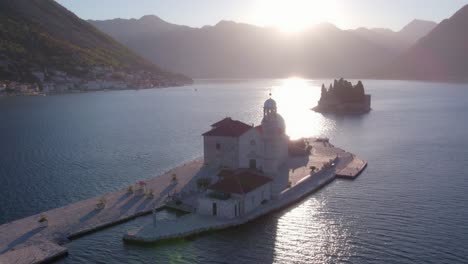Magical-bright-sunlight-shines-on-Church-of-Our-Lady-of-the-Rocks,-Montenegro