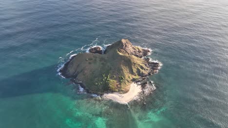 high-aerial-pan-of-mokulua-islands-at-sunrise-with-brilliant-blue-water-and-reef-at-sunrise-surrounding-island-lanikai-hawaii