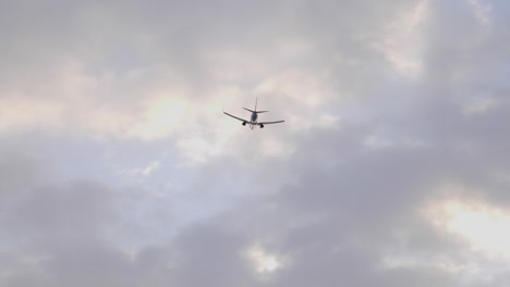 Avión-Volando-En-El-Cielo-Contra-El-Cielo-Nublado