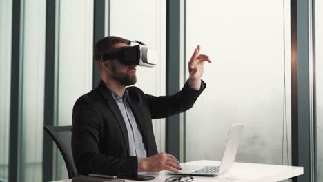 A-man-dressed-in-virtual-reality-glasses-and-business-clothes-sits-at-a-table-and-flips-through-virtual-pages