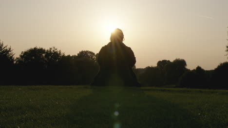 Wunderschöne-Filmische-Aufnahme-Einer-Person,-Die-Bei-Sonnenuntergang-In-Der-Natur-Silhouettiert-Ist