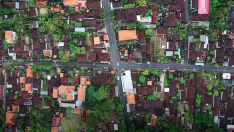 Overhead-View-Of-Cars-Driving-In-The-Street-Of-Rural-Community-In-West-Bali,-Indonesia