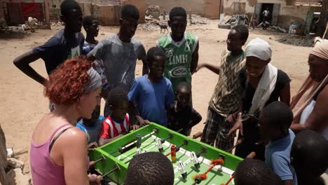 Una-Mujer-Blanca-Y-Una-Negra-Compiten-Jugando-Al-Futbolín-En-Las-Calles-De-Nouakchott,-Mauritania