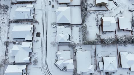 Top-down-aerial-view-of-a-residential-neighborhood-covered-in-snow
