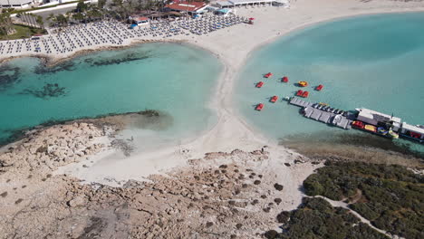 Aerial-of-sandy-walkway-amidst-the-crystal-clear-waters-of-Nissi-Beach-Ayia-Napa-Cyprus