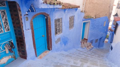 Decorated-blue-walls-from-Chefchaouen,-Steep-stairs-along-an-empty-narrow-street-in-the-old-town