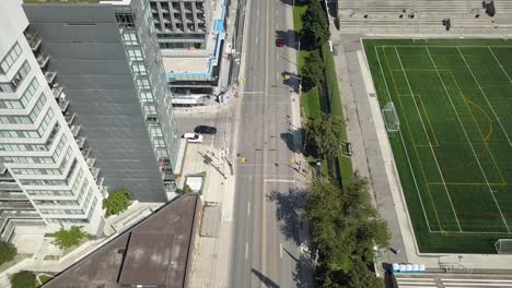 Drone-Inclinándose-Sobre-Una-Carretera-Al-Lado-De-Un-Estadio-De-Fútbol-En-El-Centro-De-Toronto