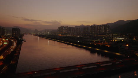 Nachthimmel-Luftaufnahme-Des-Modernen-Chinesischen-Stadtbildes-Hongkong,-Nachts-Beleuchtet-Mit-Modernem-Wolkenkratzergebäude-Und-Goldenen-Stunden-Bei-Sonnenuntergang,-Filmisches-Luftaufnahmen-Nachtleben-Konzept