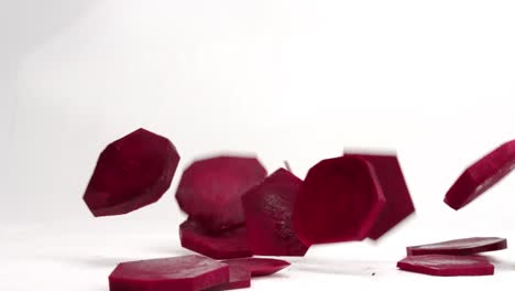 Beet-slices-falling-and-bouncing-on-white-backdrop-in-4k-slow-motion