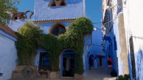 Tilt-down-shot-from-two-floor-blue-painted-building-in-a-charming-alley-in-Chefchaouen