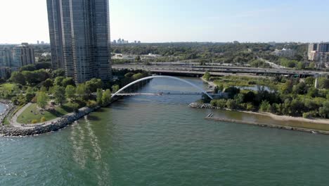 Drone-flying-away-from-a-bridge-and-the-Gardiner-Expressway-on-Lake-Ontario-in-the-summer