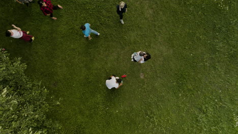 Vista-Aérea-De-Familias-Jugando-Juntas-En-Un-Césped-Verde,-Ilustrando-El-Vínculo-Familiar