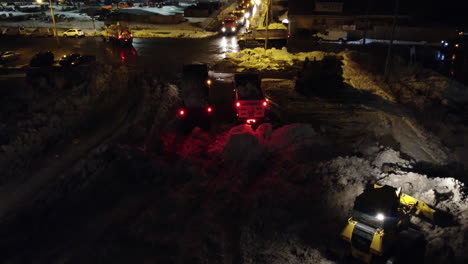 Trucks-And-Bulldozer-Working-Hard-At-Night-At-The-Snow-Dump-Full-Of-Snow-Caused-By-Winter-Storm-In-Buffalo,-New-York
