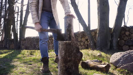 Bottom-view-of-caucasian-man-chopping-firewood-with-an-ax-in-the-countryside