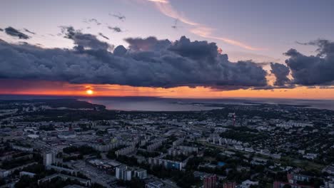 Aerial-hyperlapse-of-cityscape-of-Tallinn-in-Estonia,-dramatic-sunset-clouds,-sideways