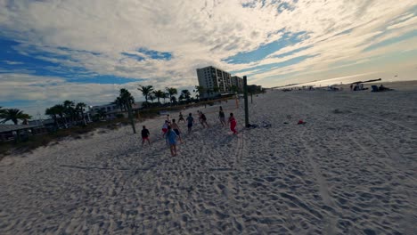 FPV-drone-shot-of-people-playing-beach-volleyball-on-Florida-beach-on-a-sunny-day-at-Madeira-Beach