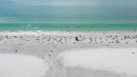 People-chilling-on-white-sand-of-wide-Siesta-Key-Beach,-beach-is-groomed-and-ocean-water-is-turquoise