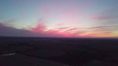 Unglaublicher-Rosafarbener-Sonnenuntergang-über-Ländlichen-Englischen-Landwirtschaftlichen-Feldern-Mit-Stehendem-Wasser-Und-Pfützen
