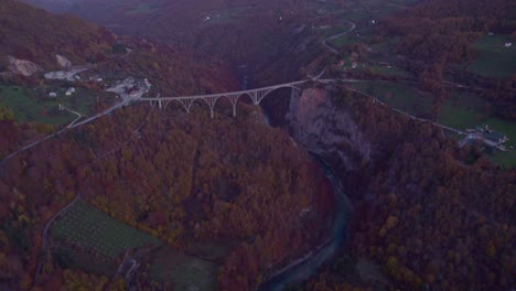 Reveal-shot-of-Durdevica-Tara-Bridge-in-Montenegro-during-fall-season,-aerial
