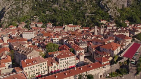 Medieval-harbor-town-Kotor-in-Montenegro-during-sunset-sunlight,-aerial