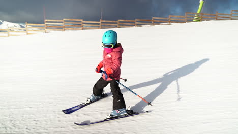 Junges-Mädchen-Lernt-Skifahren-Und-Fährt-Langsam-Den-Flachen,-Leeren-Hang-Hinunter