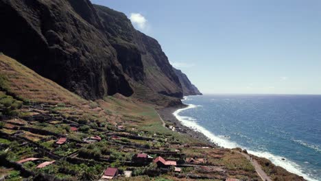 Aerial-reveal-of-tourist-destination-Achadas-da-Cruz-on-volcanic-green-Madeira-coastline