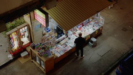 top-down-view-of-asiatic-male-standing-in-news-kiosk-buying-newspaper-for-reading-breaking-news