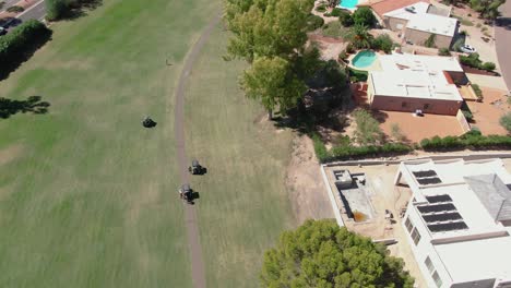 Overhead-aerial-view-of-golfers-getting-into-their-respective-golf-carts-before-moving-onto-the-next-hole-in-Phoenix,-Arizona