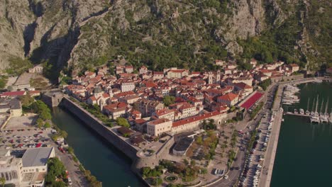 Medieval-harbor-town-Kotor-with-mountain-background-in-Bay-of-Kotor,-aerial