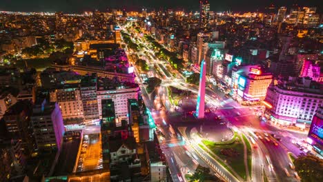 Aerial-Hyperlapse-Above-Buenos-Aires-Obelisk,-Argentina,-Night-in-9-de-Julio-Avenue-and-City-Center,-Vibrant-Lights-and-Colors,-Urban-Transportation-in-Motion