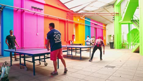 Men-Playing-Ping-Pong-Against-Colorful-Wall-At-The-Recoleta-Cultural-Center-In-Buenos-Aires,-Argentina