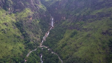Aerial-tilt:-Mountain-jungle-highway-crosses-waterfall-in-Sri-Lanka