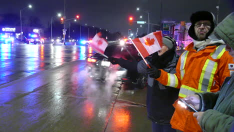 People-of-Freedom-Convoy-2022-blocking-road-with-police-cars-nearby,-handheld