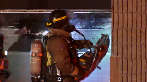 Firefighters-Trying-To-Open-The-Entrance-Of-A-Building-In-Fire-Using-Circular-Saw
