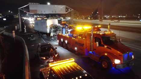 Aerial-establishing-shot-of-Crash-scene,-long-truck-accident,-Tow-truck-with-emergency-lights-on