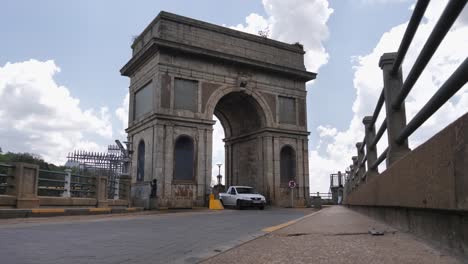 Car-traffic-drives-through-replica-arch-at-Hartbeespoort-Dam,-S-Africa