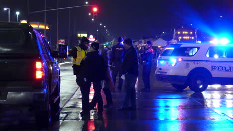 Toma-Nocturna-De-La-Parada-De-Tráfico-De-La-Policía-Durante-El-Convoy-De-La-Libertad-En-Canadá,-Vehículos-Policiales-Con-Luces-Intermitentes