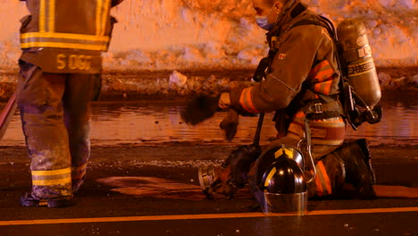 Portrait-shot-of-Firefighters-disconnecting-fireHose-during-a-Night-Urban-fire